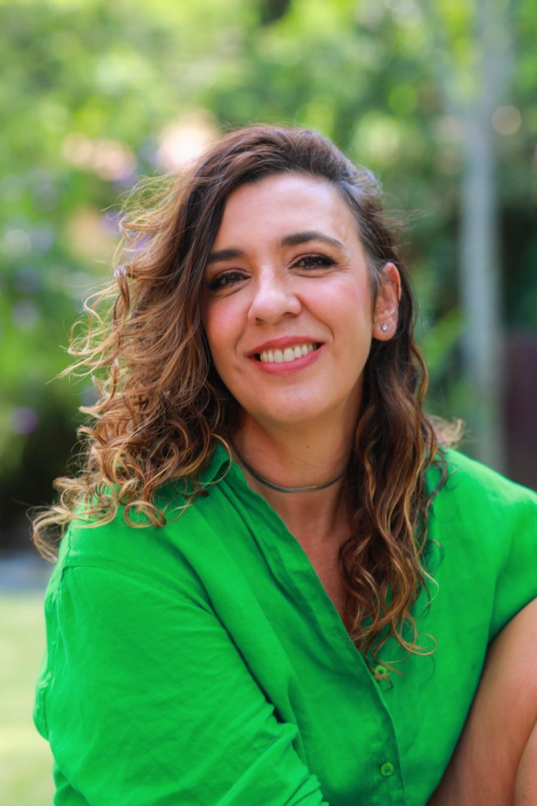 Foto de mulher (Patícia Pinho) vestida de verde e sorrindo. Palestrante do PROTEJA Talks 2024.
